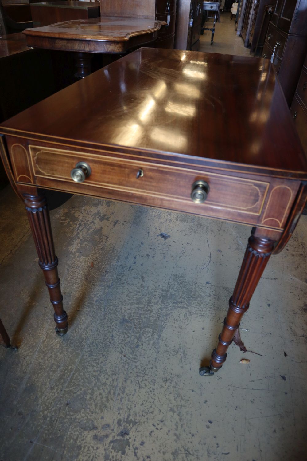 A Regency mahogany sofa table, with D shaped flats and frieze drawer on turned and fluted tapered legs, fitted brass castors, width 102
